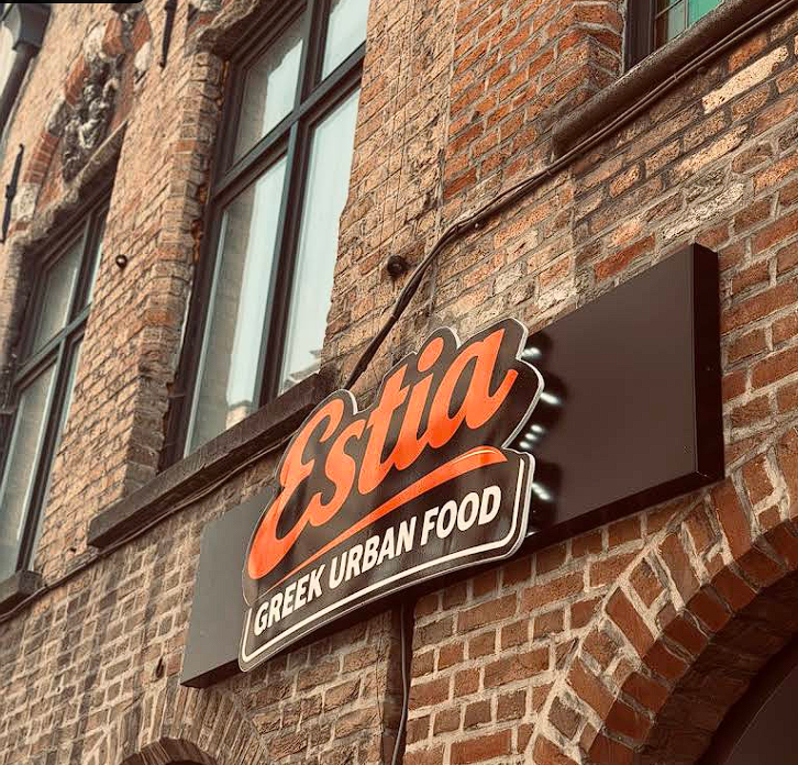 ESTIA Greek Urban Food sign on the historic brick facade in Bruges