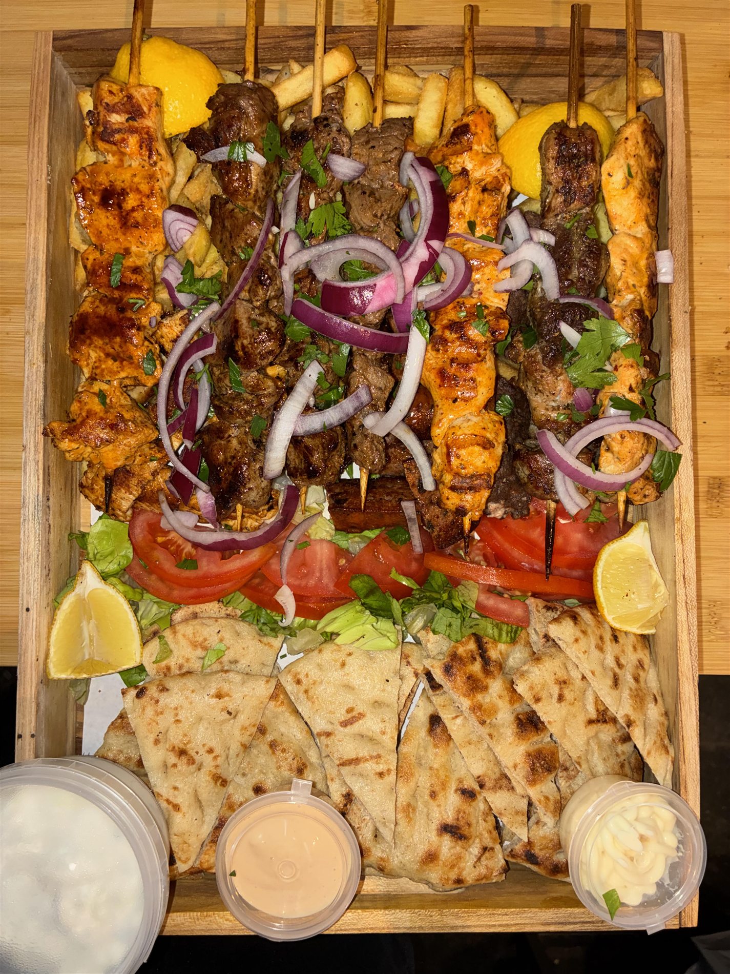 Mix Grill for 4 with chicken, beef, pork, pita, fries, sauces and fresh vegetables